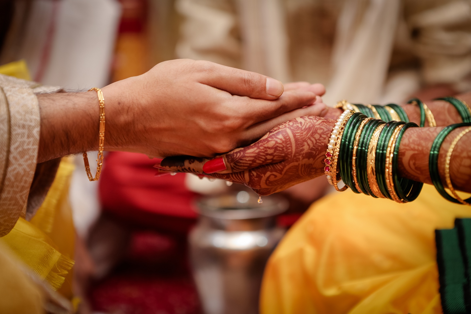 Selective focus shot of an Indian couple's hands at a wedding